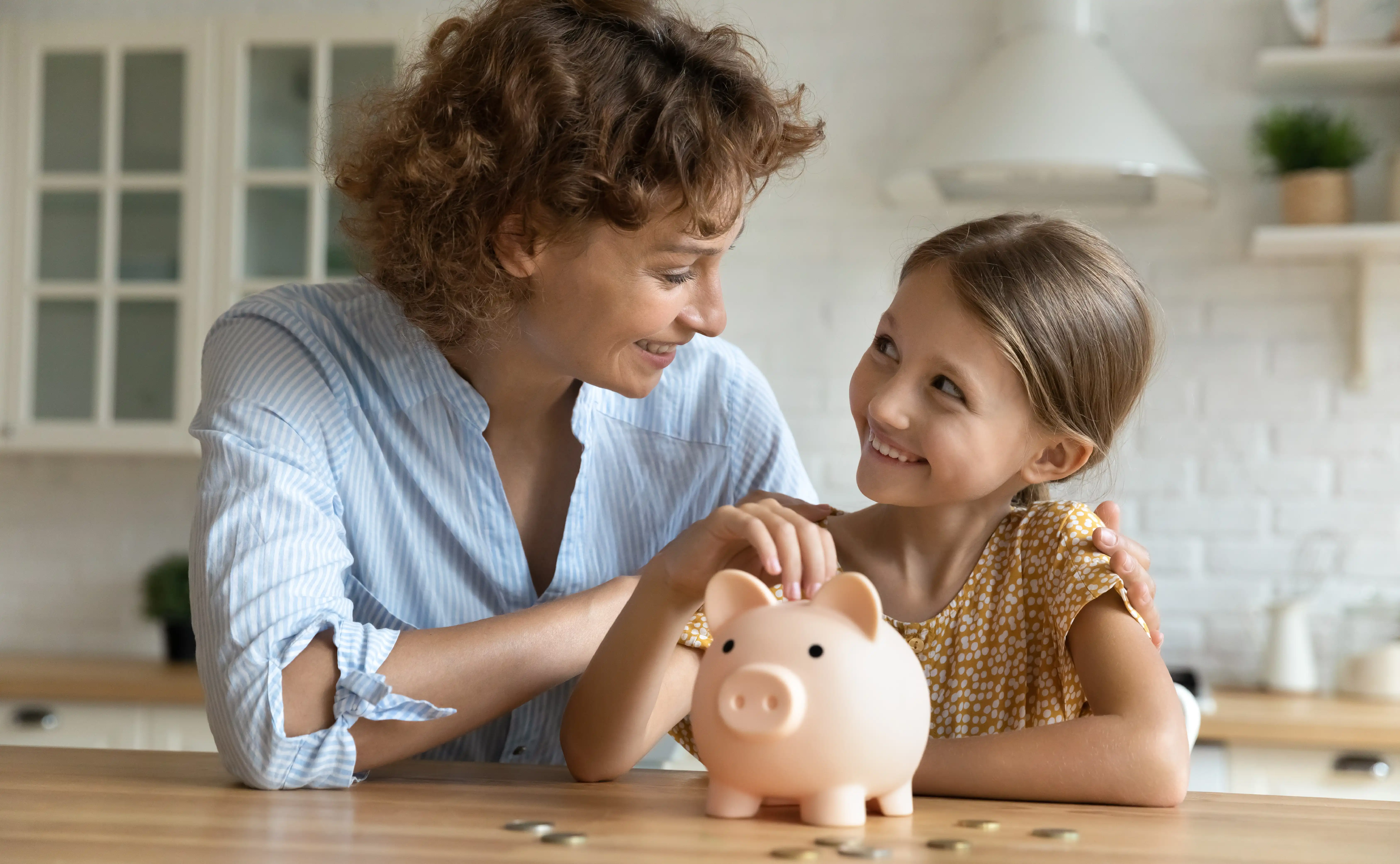 young mom teaching daughter good money habits